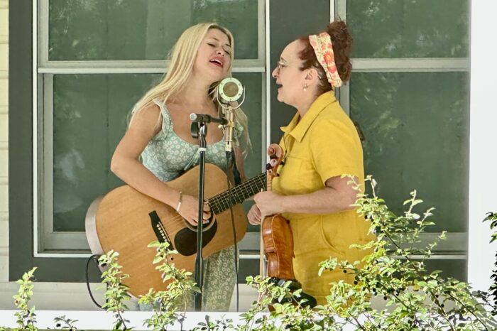 two women singing at single mic