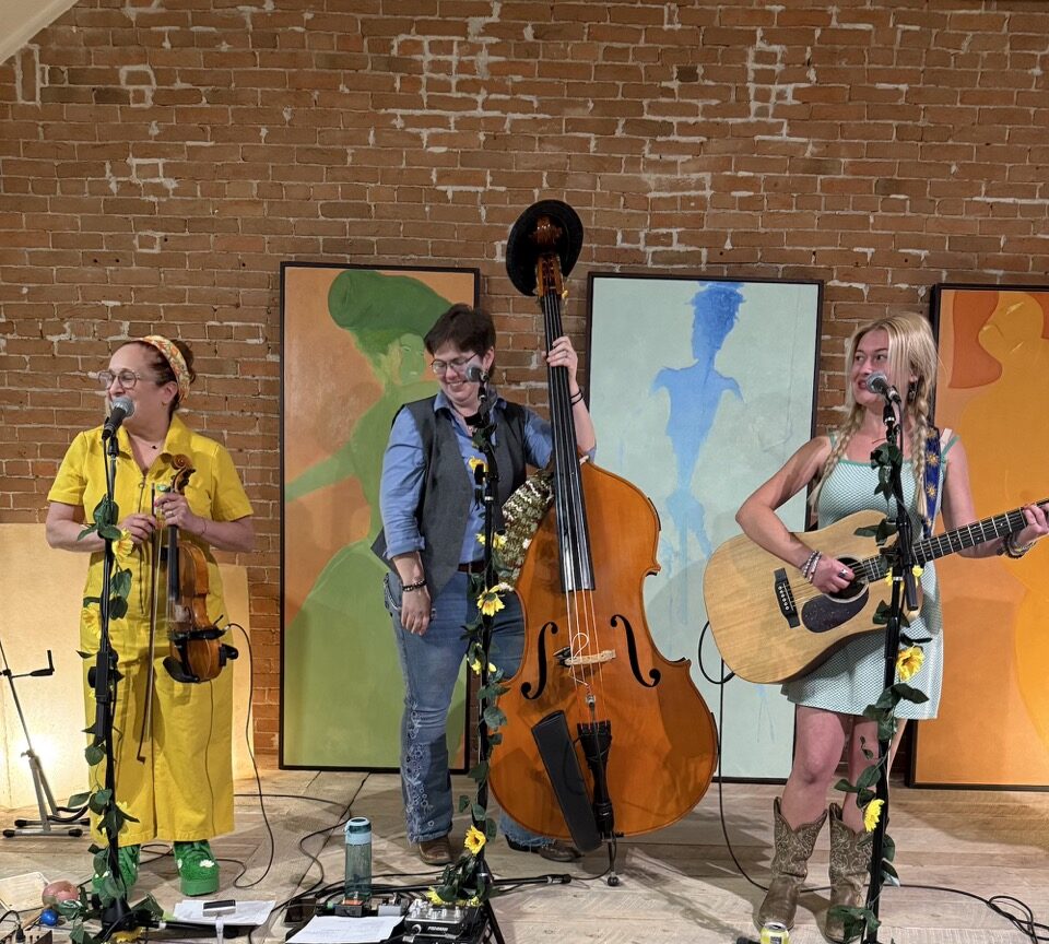 5-Foot Betty trio playing on stage at art gallery