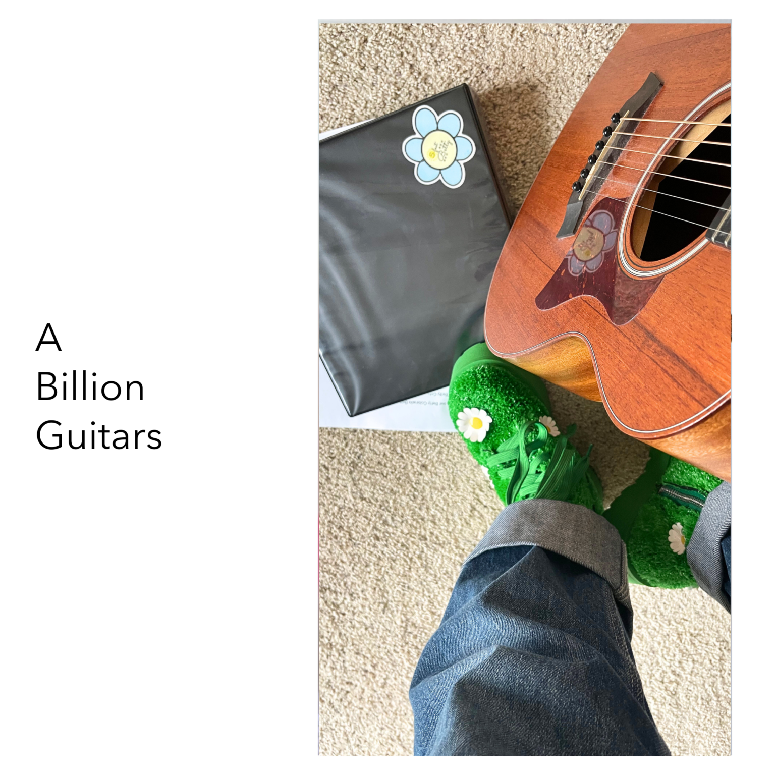 Guitar, notebook and green boots with daisies seen from above